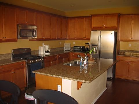 Beautifully upgraded kitchen with large center island, granite counters and stainless steel appliances. 