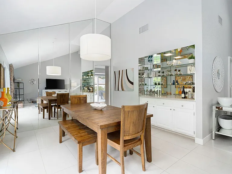 Dining area leading into kitchen with bar to right.