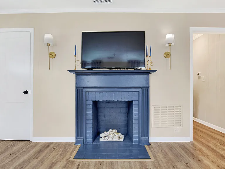 Faux fireplace with sconces. 1 of two flat screen smart TV's