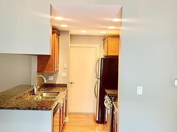 View from patio door into kitchen. Lots of can ceiling lights (on dimmer). Doorway to attached garage in kitchen.