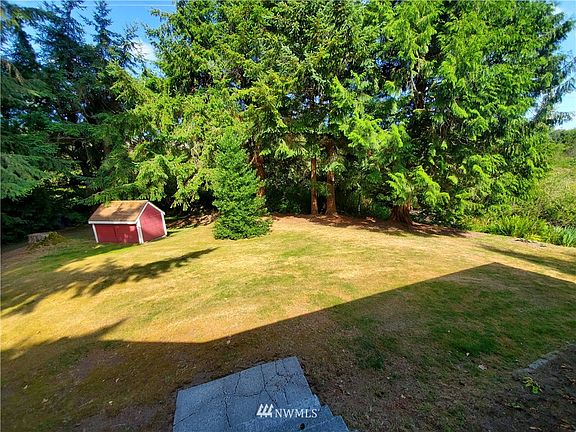 View from the front door of the home across yard with well house