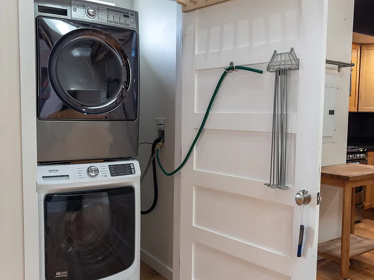 Full-sized stacked washer and dryer storage closet.