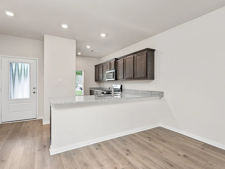 The kitchen has wood cabinetry and sprawling granite countertops.