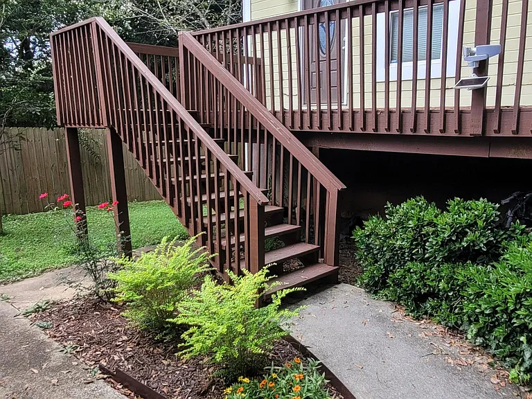 Front deck overlooking raised garden beds. Plus many established shrubs, flowers, and flowering crepe myrtle trees on the property.