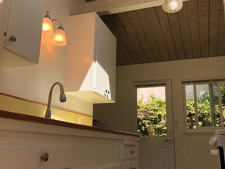 Kitchen view with the side exterior door and window, with the view of the skylight in the kitchen.