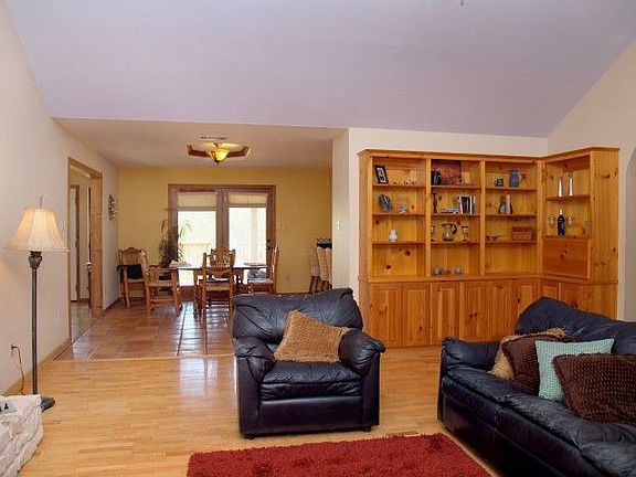 Living room has wood floors and built-in shelving.