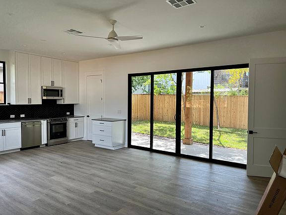 Open concept kitchen, pantry, and sliders that open to covered patio and yard