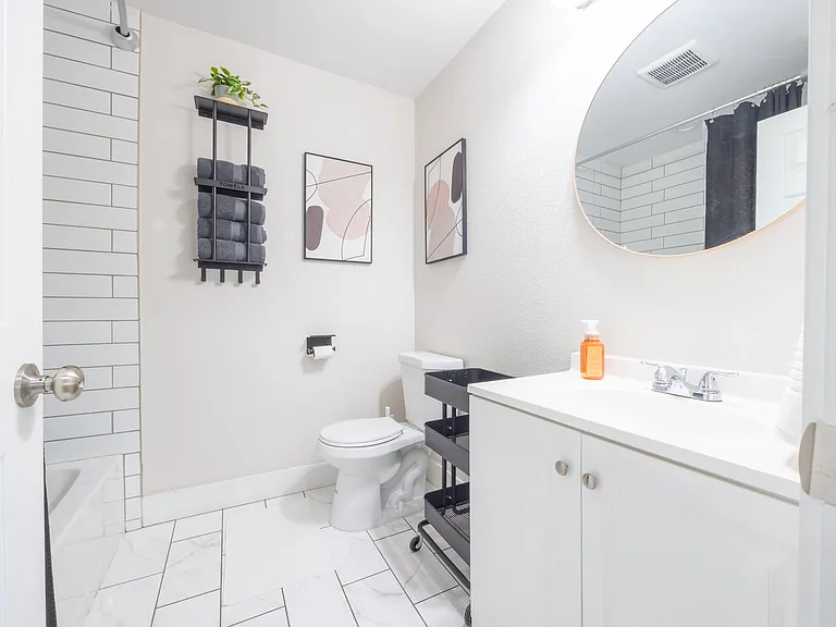 Upstairs Guest Bathroom w/ bathtub, storage, and essentials.