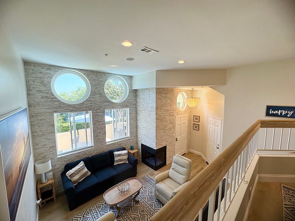 open concept over looking living room with stacked stone and gas fireplace
