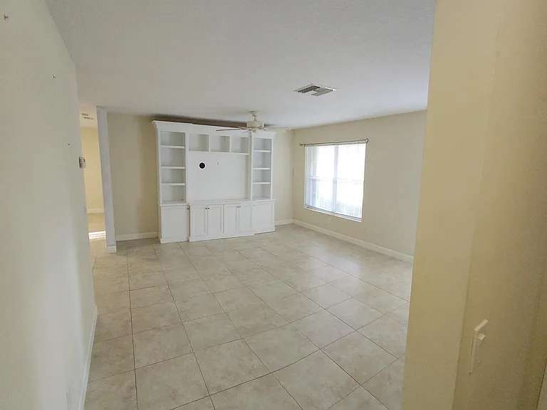 Looking from bedroom hall into living room. Built-in on North wall