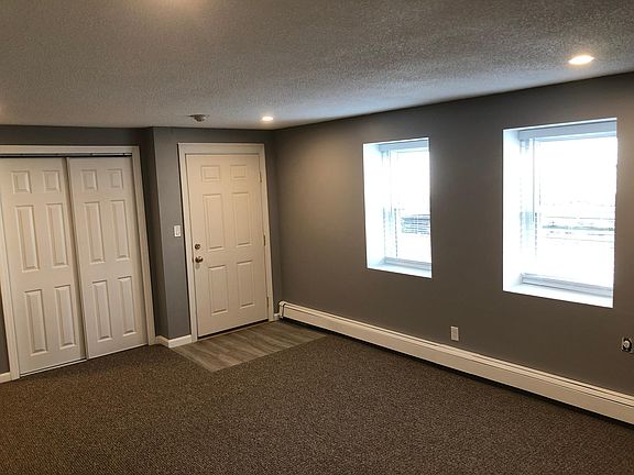 Large living room with new doors, windows, plantation blinds, closet lighting, LED canister lights and carpet/flooring.