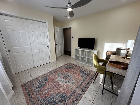 Bedroom with generous size closet. Modern computer desk, chair, rug, shelving and TV for tenant use.