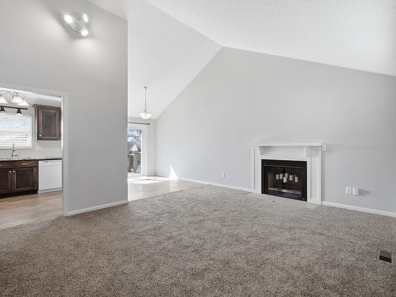 living room with vaulted ceiling and fireplace