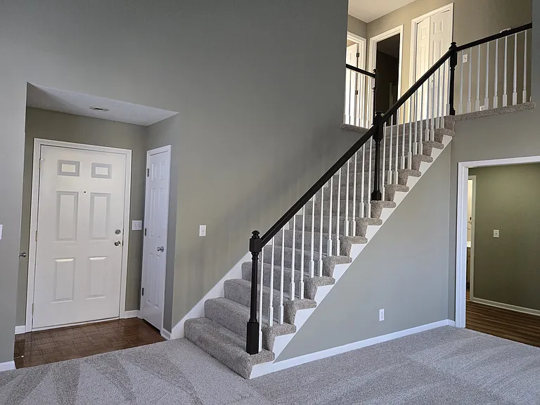 Entrance door, 2 coat closets on either side of the entry door, stairs to bedrooms upstairs