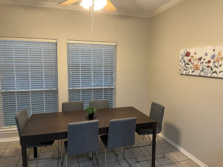 Dinette - furnished with table and six chairs, plus wall decor. Shared space.