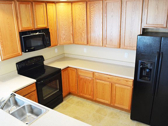 Tons of storage and black appliances are featured in the kitchen.