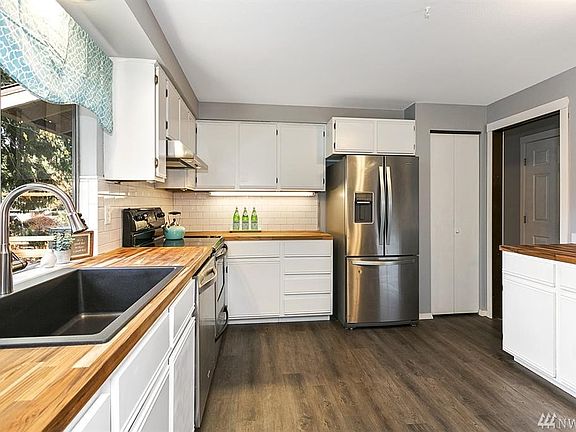 NEW FLOORING, COMPOSITE SINK, BUTCHER BLOCK COUNTERS & SUBWAY TILES. STAINLESS STEEL APPLIANCES STAY WITH HOME.