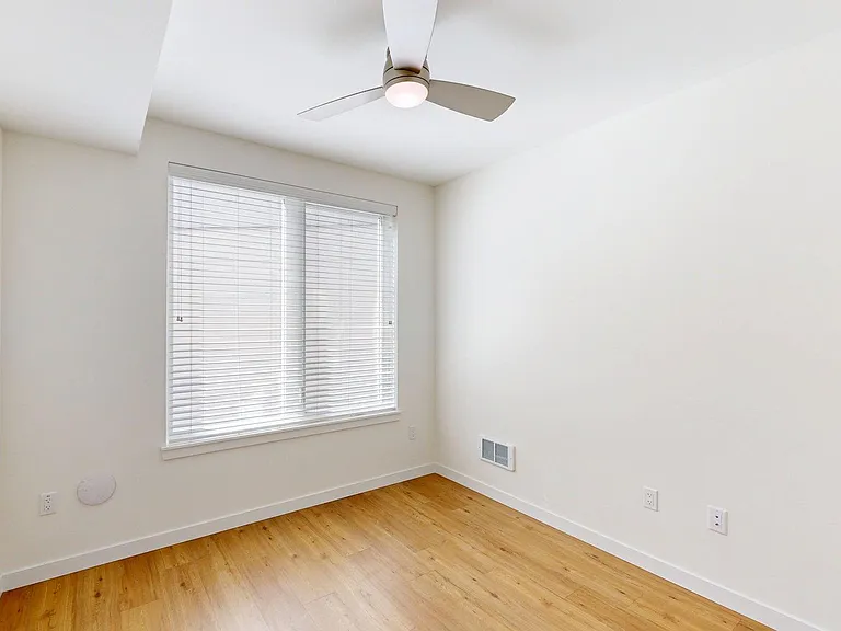 Spacious apartment Bedroom with Wood-Style Flooring.