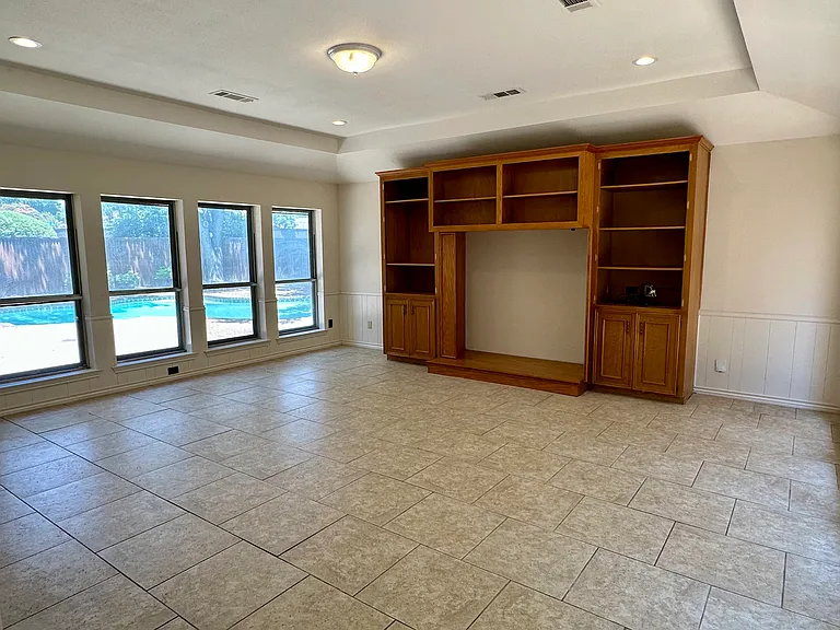 Family room featuring a tray ceiling, recessed lighting and a view to the pool outdoors