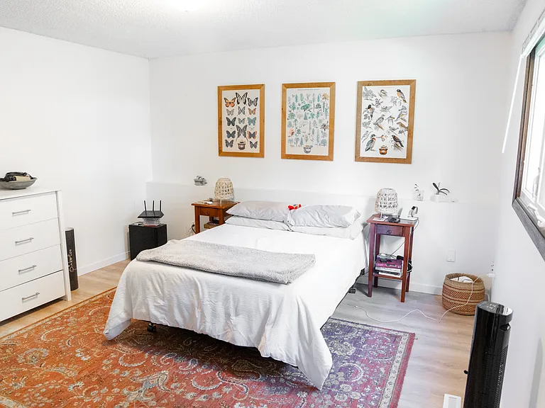 Spacious primary bedroom pictured with queen size bed.