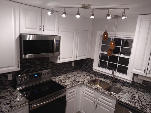 Kitchen includes mosaic backsplash, granite counters