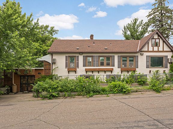 Property Side View. Current residents maintain a vegetable garden and raspberry patch on the side of the building.