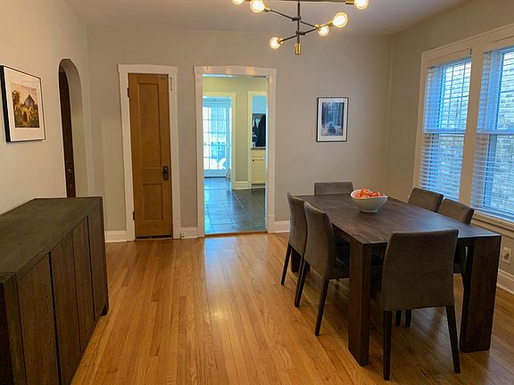 From the front stairway entrance, dining room view of the kitchen, mud-room, and rear entrance. The door on the left leads to the second and third bedrooms and the second bathroom.
