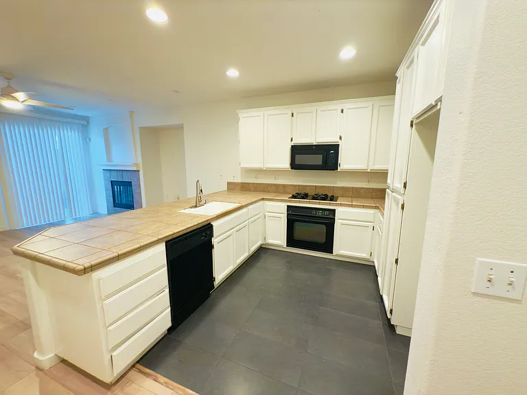 The kitchen boasts a sleek U-shaped modern design, high ceilings, and the perfect layout for cooking and entertaining!