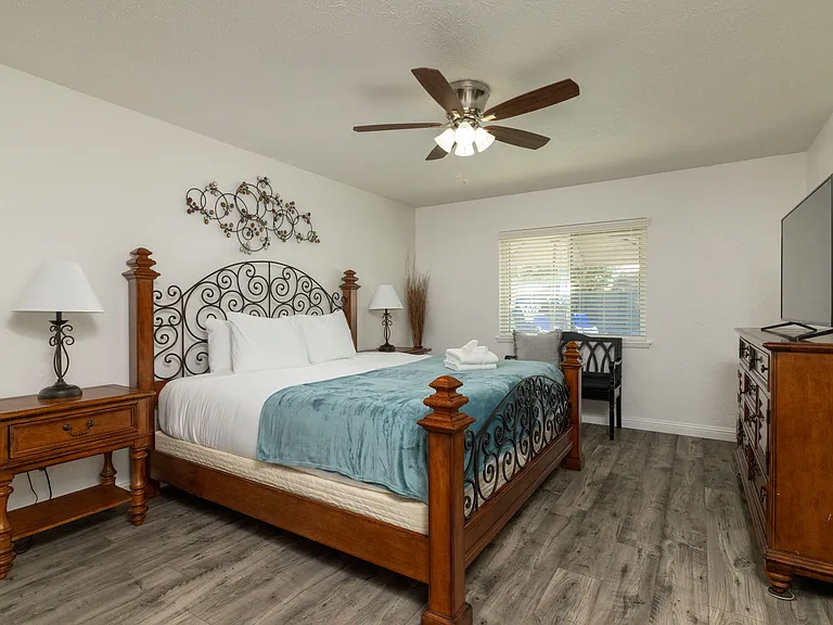 Relax in the primary bedroom featuring a luxurious king-size bed, full-body mirror, flat-screen Roku TV and an attached bathroom for your convenience. Don't forget the luggage carrier and hangers in the large, walk-in closet!