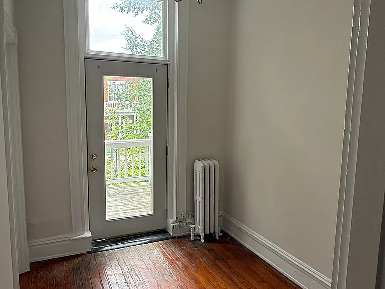 Bonus trunk room, ideal for a home office or nursery, with hardwoods and chandelier, leads out to the front porch.