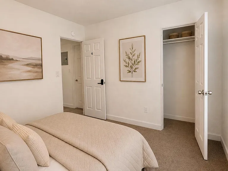 Well-kept bedroom with a comfortable bed setup, soft carpeting, and a dedicated closet for convenient storage.