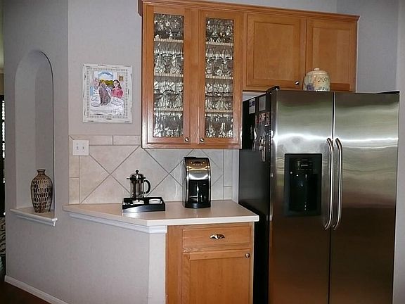 RECENT GLASS FRONTS TO ACCENT THE KITCHEN,TILE BACKSPLASH AND CORIAN COUNTERTOPS