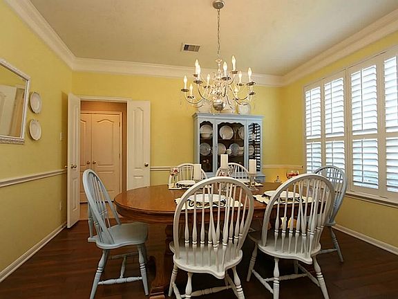 Fabulous cheery formal dining room features laminate wood flooring, Plantation shutters, crown moldi