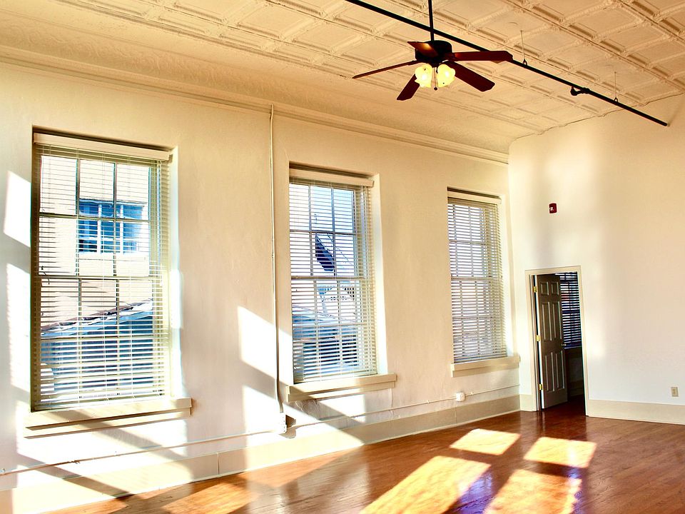 Hardwood floors throughout, no carpet. 20-ft. ceilings. Large windows with window treatments.