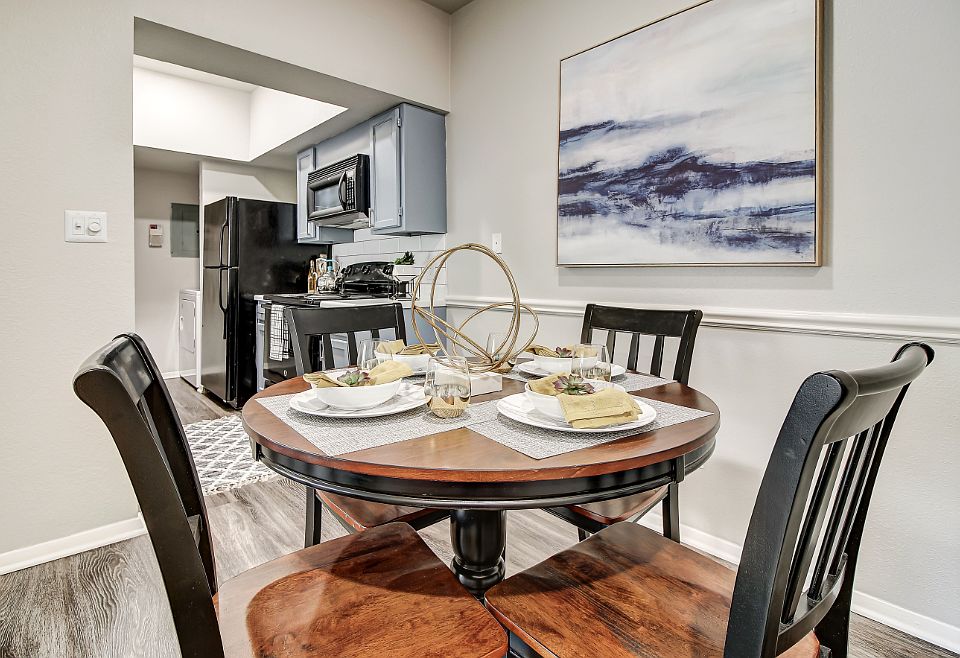 Dining room overlooking kitchen with wood-style flooring & modern light fixture