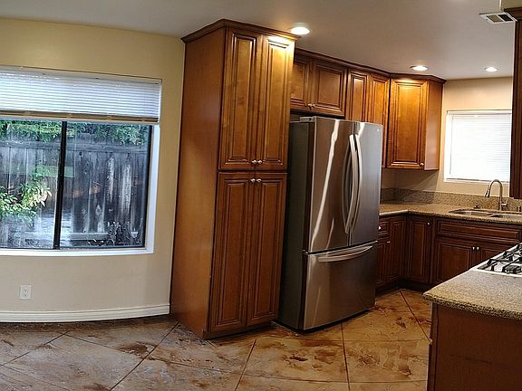Beautiful kitchen with newer cabinets and newer stainless fridge.