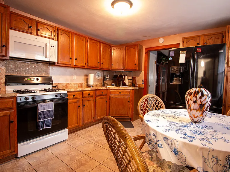 Kitchen is equipped with gas stove, microwave, side-by-side refrigerator/freezer and ice maker as well as water dispenser