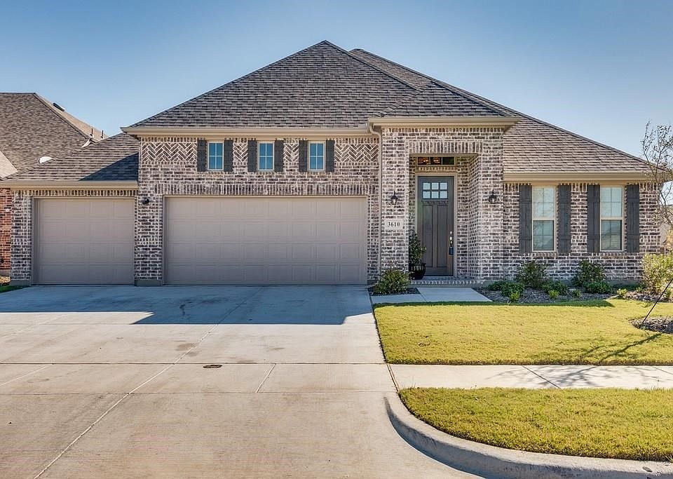 Stunning elevation with detailed brick work & cedar shutters + 3 car garage!