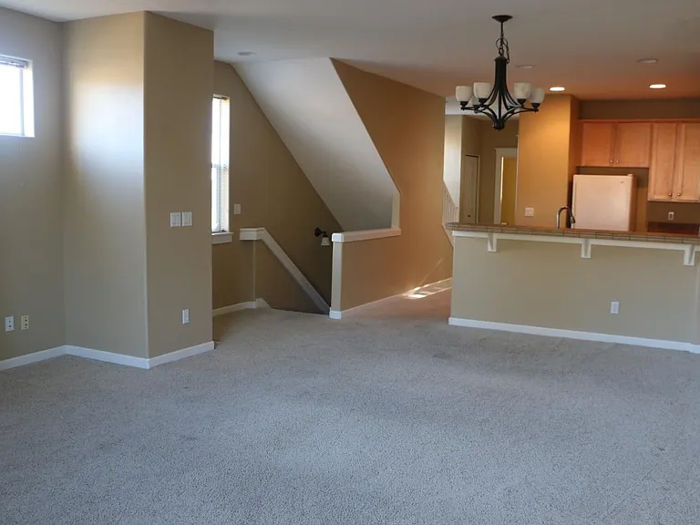 Living room looking toward kitchen and stairs down to the front door.