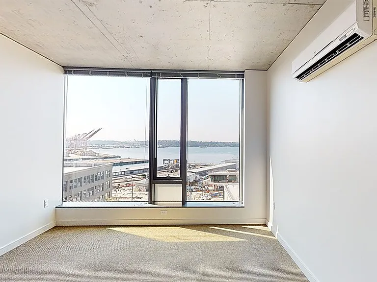 Spacious apartment bedroom with plush carpet flooring.