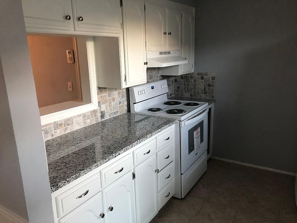 Newly remodeled kitchen with plenty of storage, a new stove & vent hood along with a view looking into the living room.
