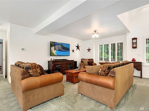 Hardwood entry and custom white shutters on windows.
