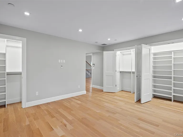 Primary bedroom with 3 of the 5 closets pictured