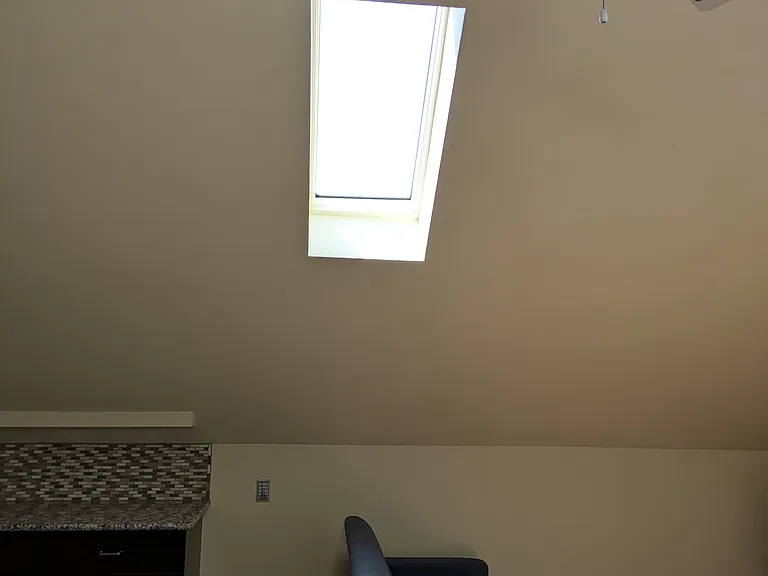 Great room -- skylight, kitchen area on the left, couches / TV on the right