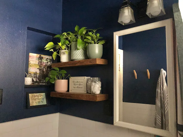 Blue Painted Bathroom with Tub Shower, White Subway Tile, Updated Wooden Floating Shelves