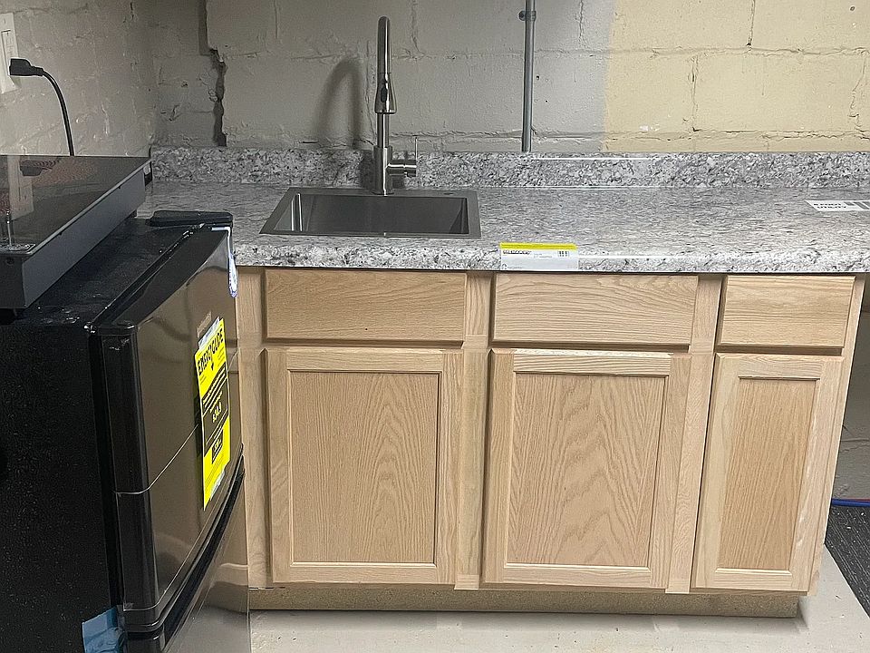 New kitchenette: counter, sink, cabinets, fridge, freezer, two-burner stove top, toaster oven. Newly installed egress window at far side of room in case of fire.