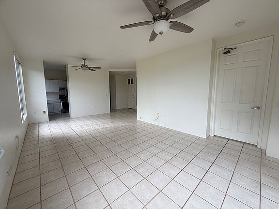 The living room is spacious and features ceiling fans for comfort
