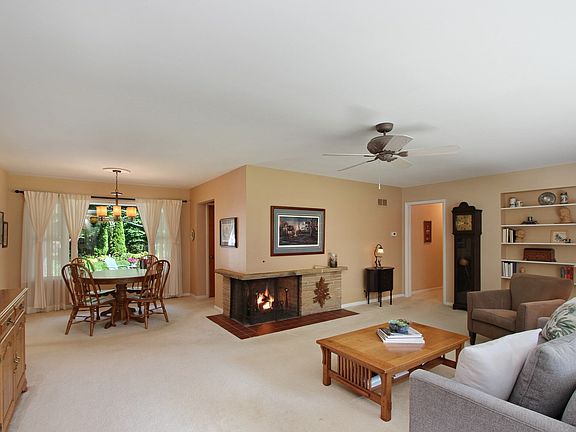 CHARMING CORNER FIREPLACE ACCENTING THE LIVING ROOM AND DINING ROOM