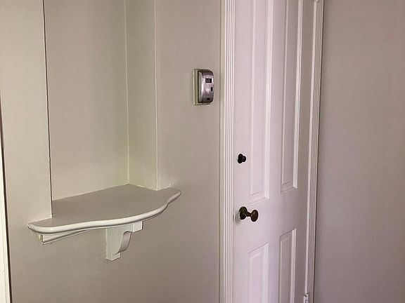 Hallway between main living area and kitchen. Door to shared washer and dryer in garage.