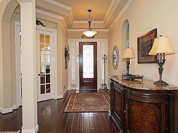 Grand foyer with 5" plank wood floors, elegant crown molding, and custom lighting.